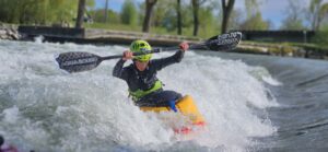 Gutt i elvekajakk med sort åre