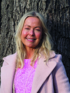 smilende lyshåret kvinne med rosa kåpe