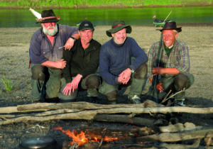 Fire menn på ekspedisjon ved bålet